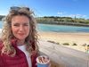 Sara enjoying a coffee by a Cornish beach